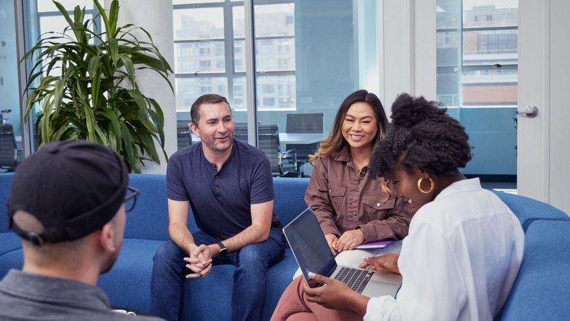 Adyen team members chatting together on couches in office