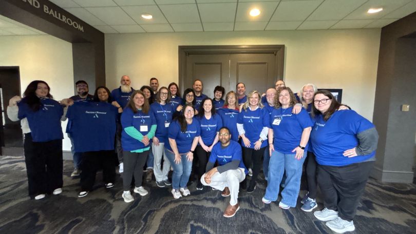 A group of Applied Systems employee pose in matching shirts
