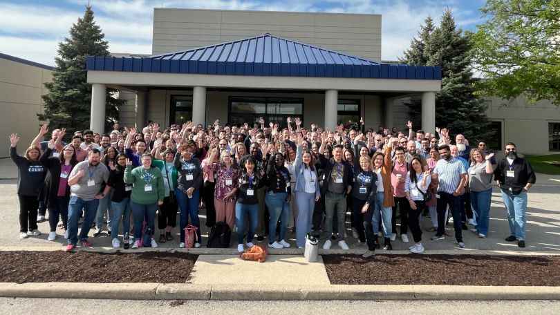 A group of Applied Systems pose for a photo outside.